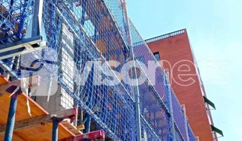 Protección vertical con redes azules en obra